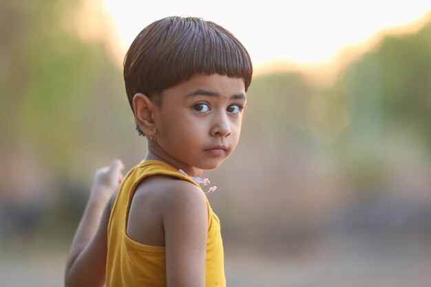 地面で遊んで幸せなインドの女児