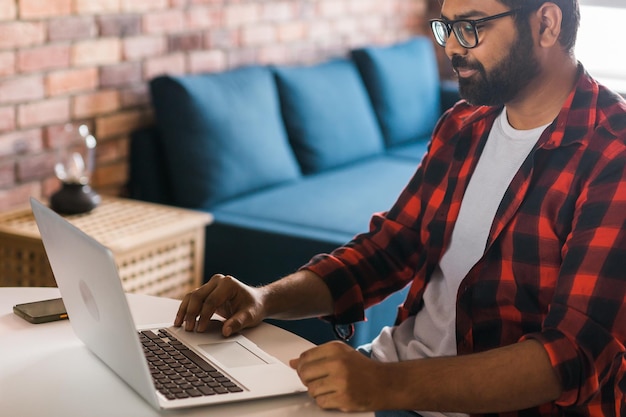 Happy indian man freelancer or entrepreneur have video conference talking working remotely online at home office video call and diversity concept