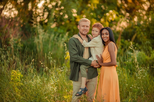 happy international family walking in the park in summer