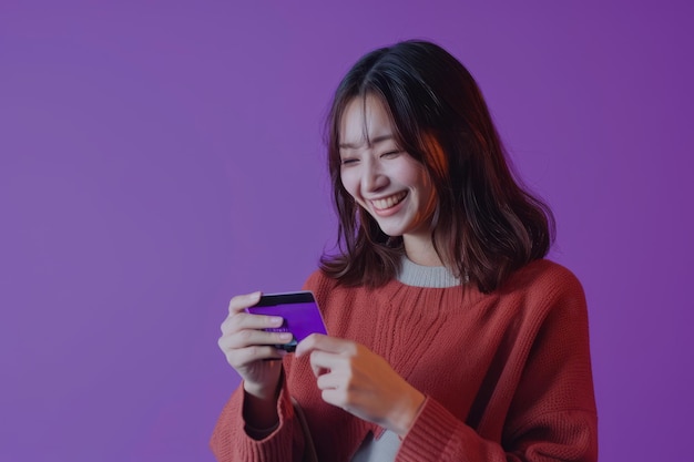 A happy Japanese woman uses a card for payment against a vibrant purple background showcasing the efficiency and ease of electronic transactions