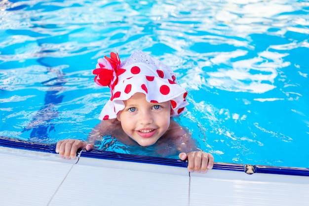 Happy and joyful baby girl swims in the pool in the summer in Panama and smiles the concept of travel and recreation