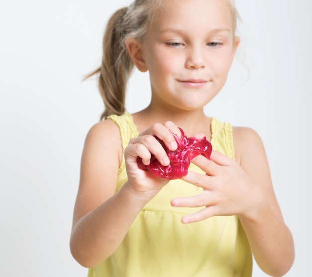 Happy joyful girl playing a red slime