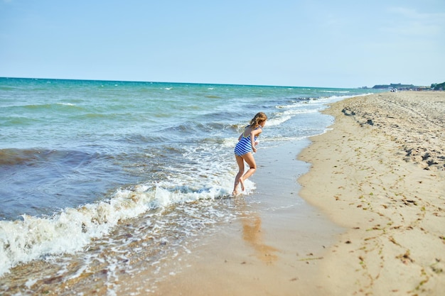 Happy joyful little girl run on the beach