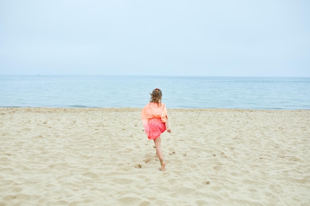 Happy joyful little girl run on the beach