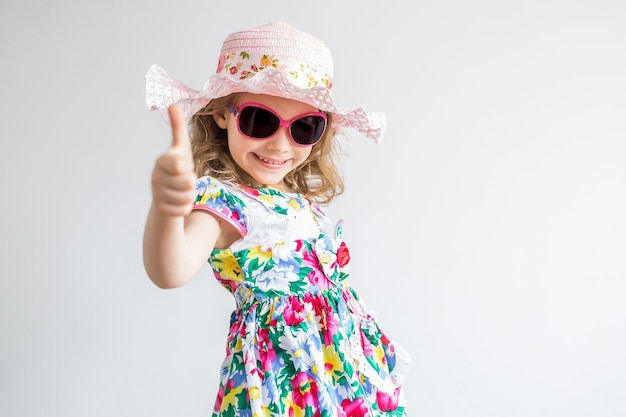 Happy joyful little girl smiling showing thumbs up