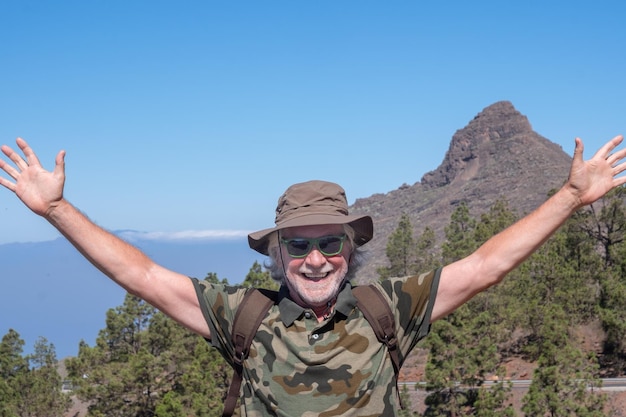 テネリフェの幸せな幸せな高齢者 バックパックを背負って 山頂でトレッキングの日を楽しんでいます