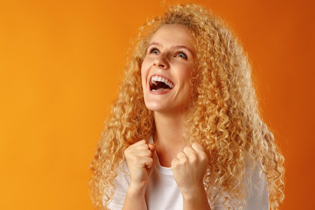 Happy joyful smiling young woman celebrating success