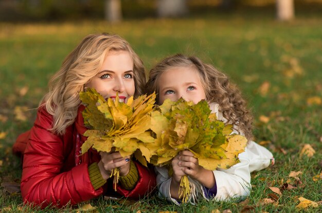 Happy joyful woman having fun with her girl in autumn color