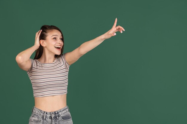 Happy joyful young caucasian woman posing isolated on green background