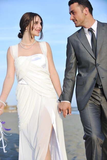 happy just married young couple celebrating and have fun at beautiful beach sunset