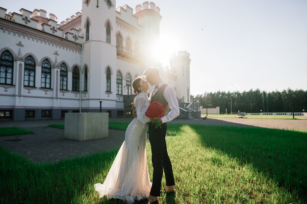 幸せなちょうど結婚されていた若いカップルを祝って、屋外で楽しんで