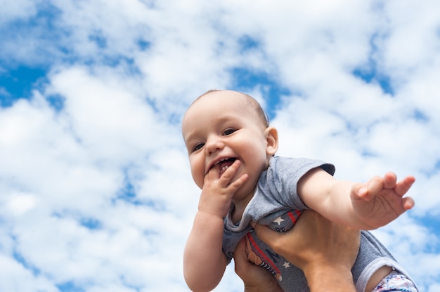 青い空と雲の背景に喜んでいる子供