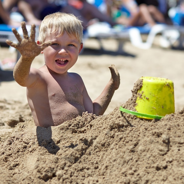 Happy kid boy playing on a beach