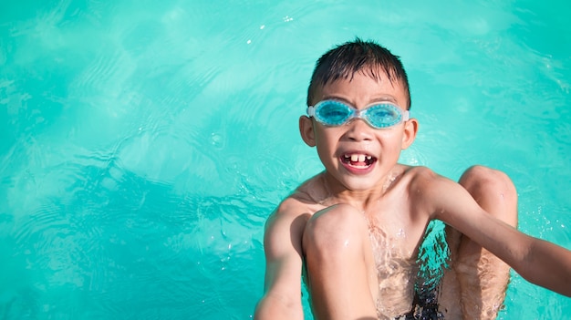 Happy kid boy in swimming pool