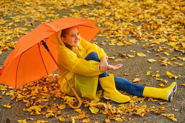 Happy kid catching rain drops in Autumn park