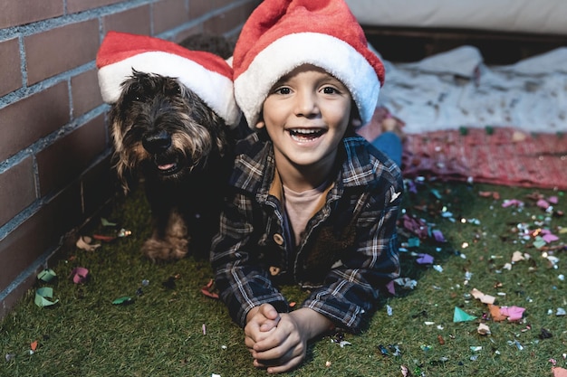 Happy kid celebrating christmas party with pet dog focus on boy\
face