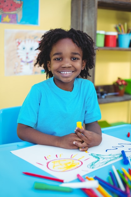 Happy kid drawing on his sheet