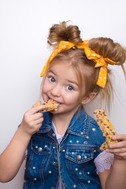 Il bambino felice mangia una barretta di frutta uno spuntino sano