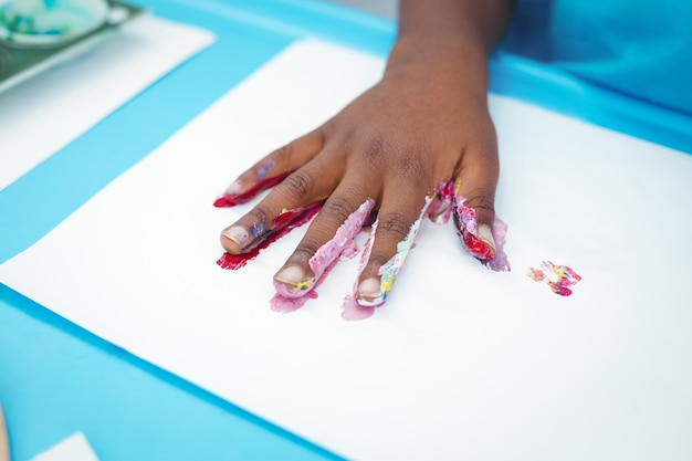 Happy kid enjoying painting with his hands