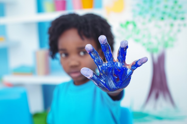 Happy kid enjoying painting with his hands