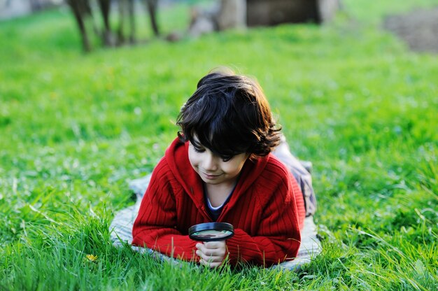 晴れた夏、秋の日、緑の草の上で自然を楽しむ幸せな子供