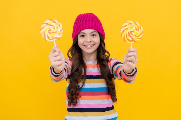 Happy kid girl hold lollipop sweet selective focus candy shop