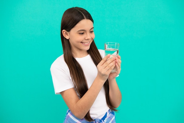Happy kid going to drink glass of water to stay hydrated and keep daily water balance in body hydration