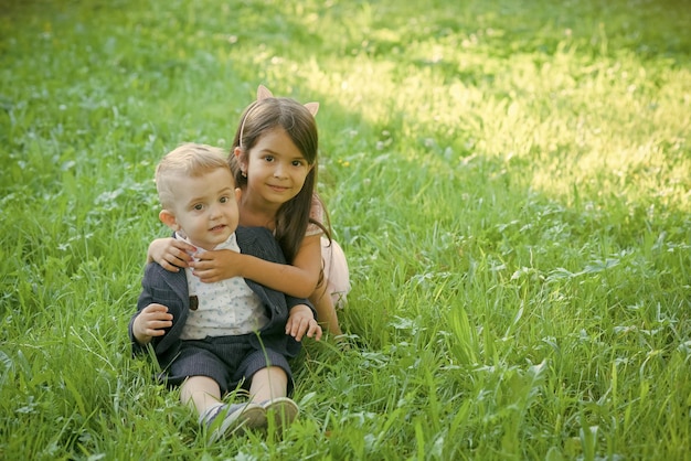 Happy kid having fun family children brother and sister on green grass family love trust concept