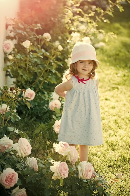 Happy kid having fun. Girl in hat with smiling in summer garden