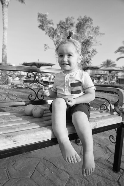 Happy kid or little boy barefoot with orange fruit