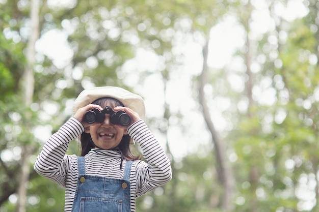 Happy kid looking ahead. Smiling child with the binoculars. Travel and adventure concept. Freedom, vacation