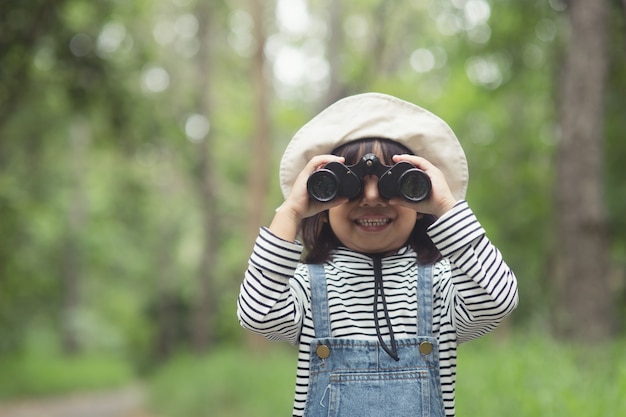 先を見据えて幸せな子供。双眼鏡で子供を笑顔。旅行と冒険のコンセプト。