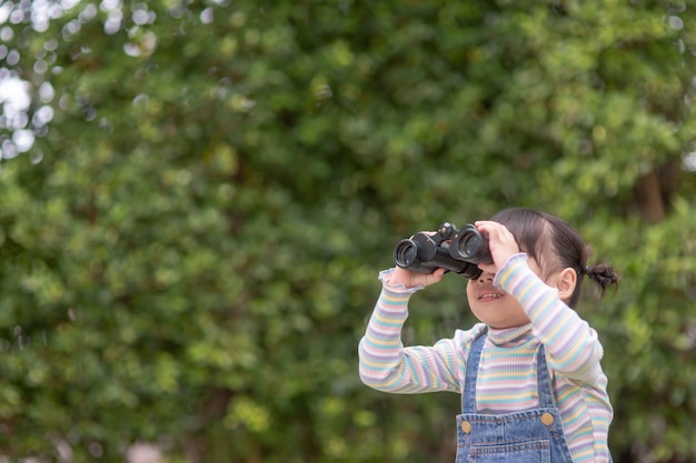 Happy kid looking ahead. Smiling child with the spyglass. Travel and adventure concept. Freedom, vacation