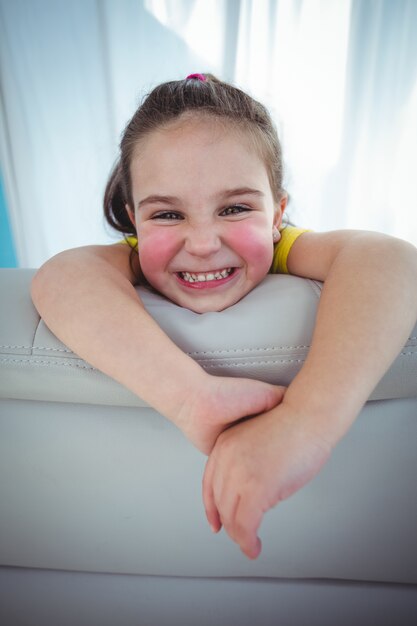 Photo happy kid looking from the back of the couch