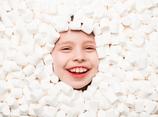 Happy kid lying in marshmallows