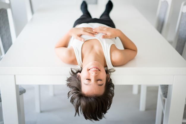 Happy kid lying on table at home