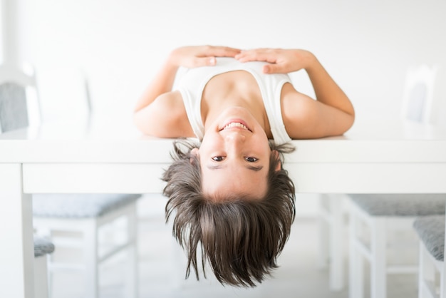 Happy kid lying on table at home