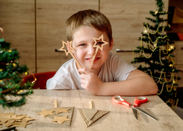 Happy kid makes a Christmas tree from cardboard. no waste, eco trends, zero waste.