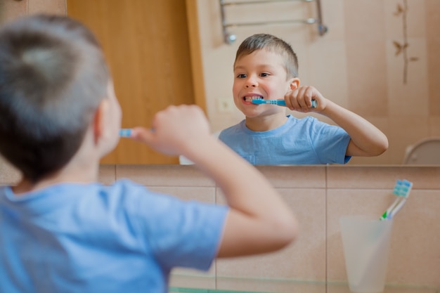 写真 幸せな子供または子供が浴室で歯を磨きます。