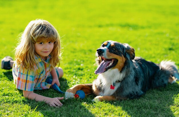 Happy kid and pet dog playing at backyard lawn cute child and puppy outside