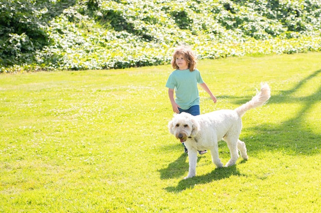 Счастливый ребенок играет с мальчиком-собакой и домашним животным отдыхает вместе в день усыновления и благотворительного животного