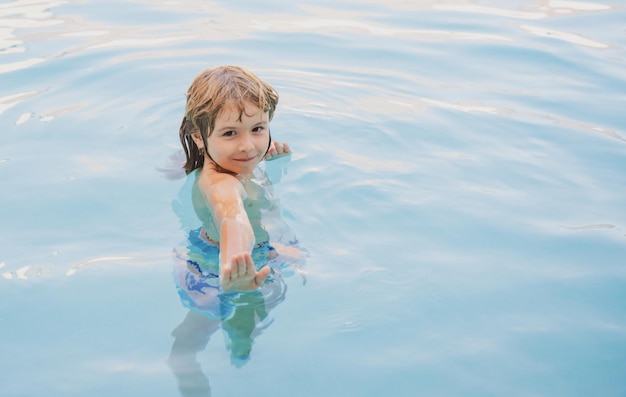 Bambino felice che gioca in piscina giochi d'acqua per bambini vacanze in famiglia e attività estive