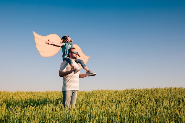 Счастливый ребенок играет с отцом на открытом воздухе в летнем поле Концепция путешествий и отдыха Воображение и свобода