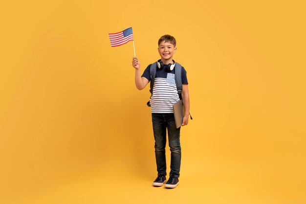 Happy kid school boy showing flag of the us