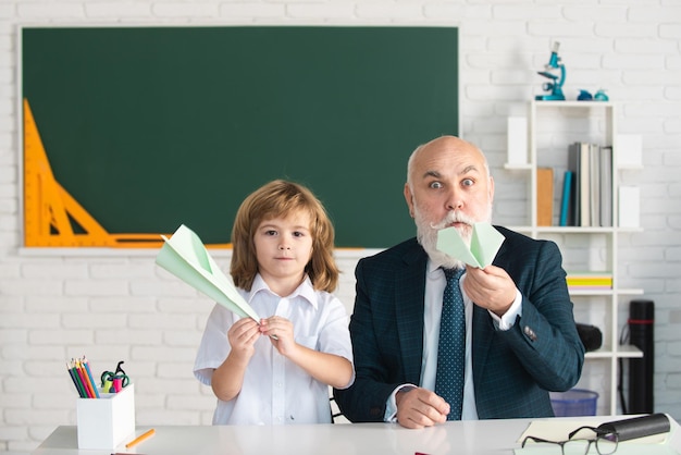 Il bambino felice nell'insegnante di scuola aiuta a imparare l'insegnamento dell'istruzione nella scuola elementare