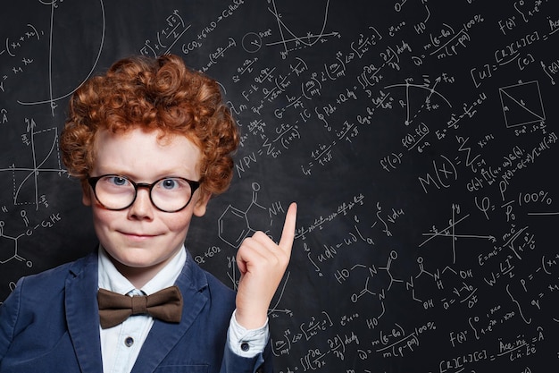 Happy kid student pointing up on science background