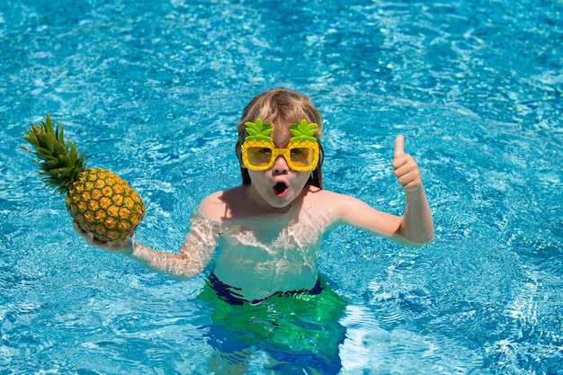 Happy kid in swimming pool on summer day Child play in tropical resort Summer vacation