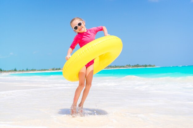 하얀 해변에 재미 풍선 고무 원으로 행복한 아이