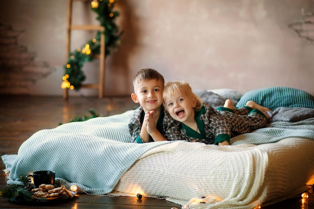 Happy kids on bed waiting for the new year