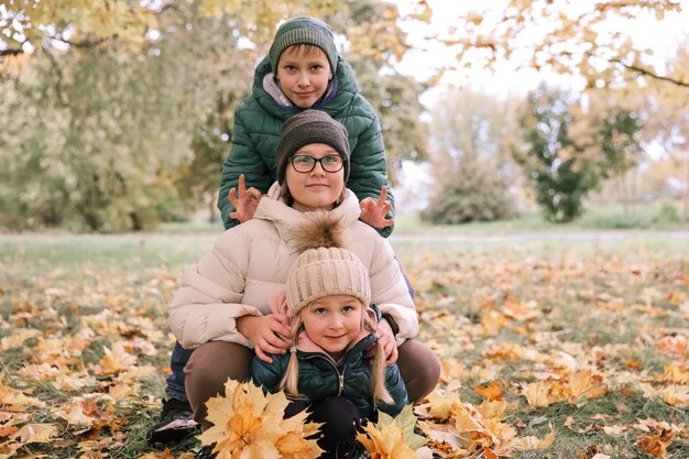 Happy kids boy and girls enjoy autumn day in the park